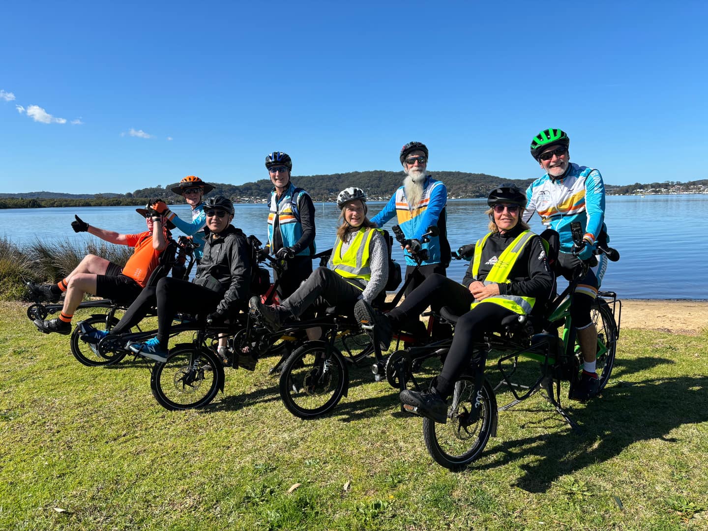 A smiling man piloting a green recumbent tandem during Pino training.