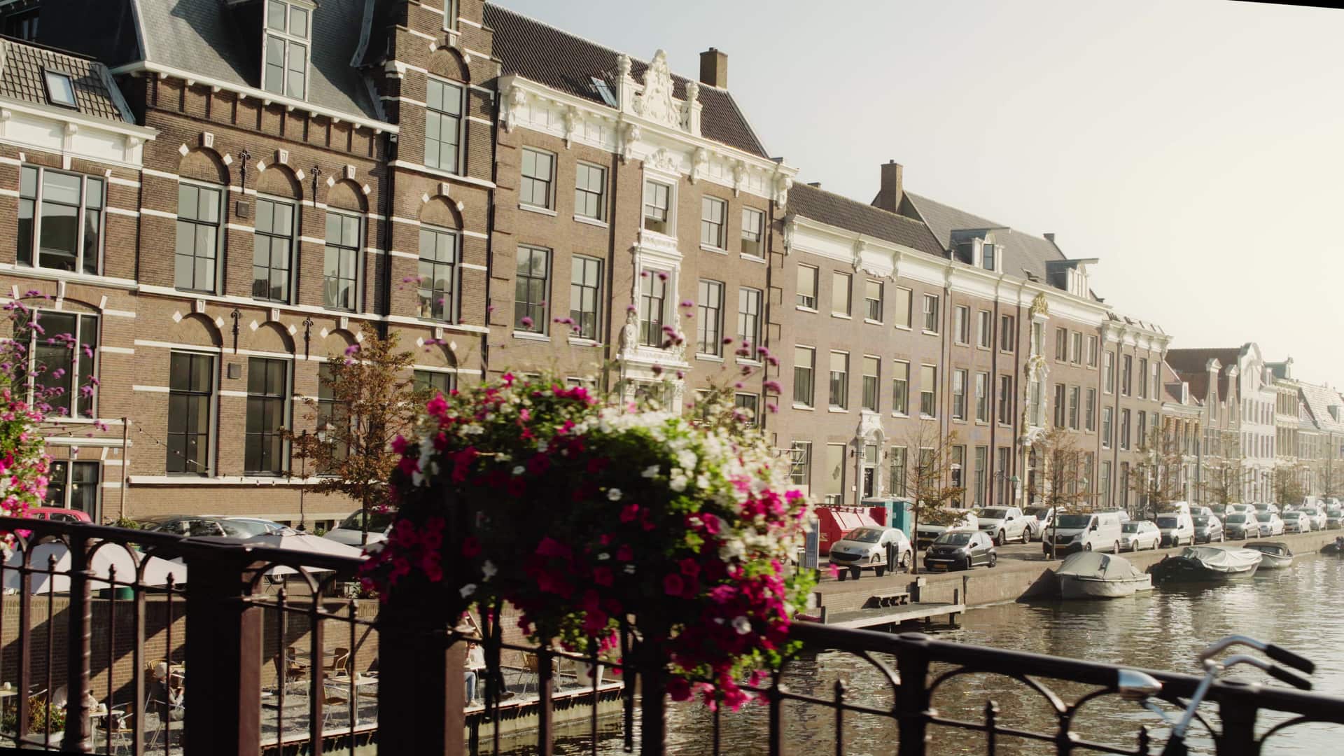 Historic canal-side buildings and moored boats on the water in Haarlem.